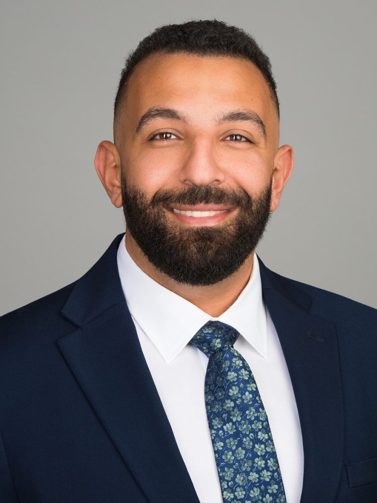 Male medical student ERAS headshot with light gray studio background, NYC
