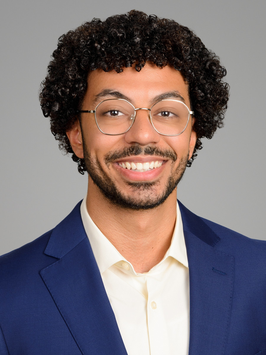 Male applicant headshot for medical residency application, light gray studio backdrop