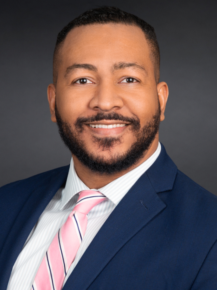 Male real estate broker headshot in NYC studio, dark gray background, corporate attire